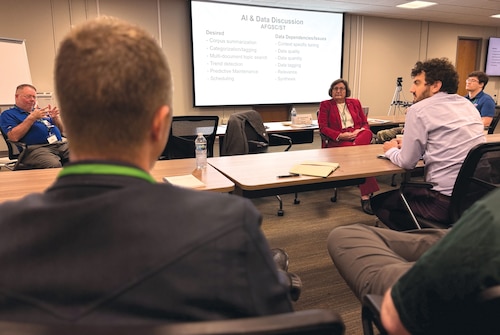 People sit around tables for a meeting