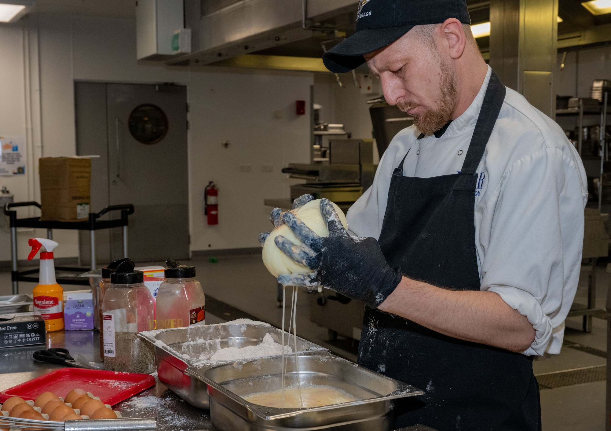 Carl Kent, 100th Force Support Squadron shift leader, prepares a fried blooming onion at Royal Air Force Mildenhall, England, Nov. 27, 2024.