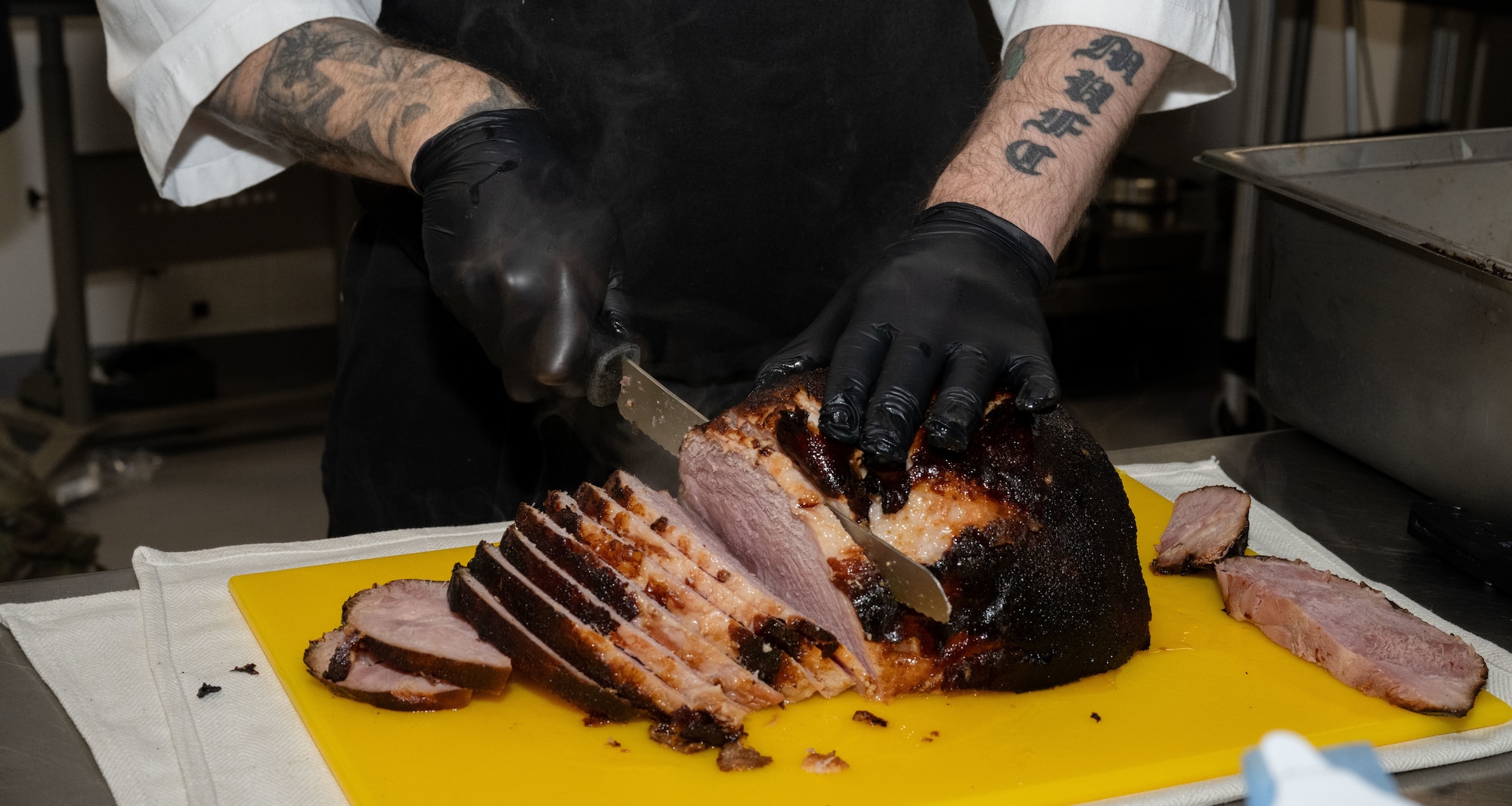 U.S. Air Force Edward Simmonds, 100th Force Support Squadron shift leader, prepares and slices a ham at Royal Air Force Mildenhall, England, Nov. 27, 2024.