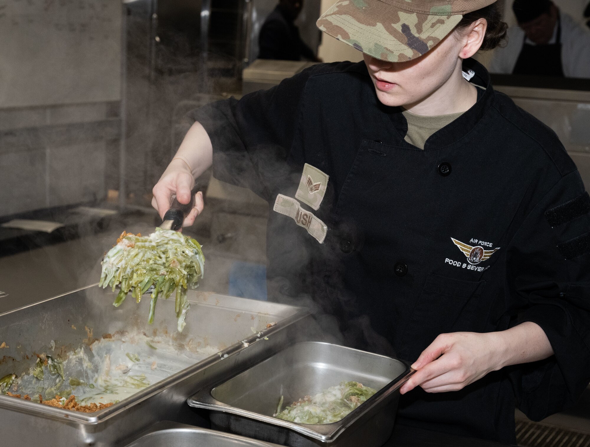 U.S. Air Force Senior Airman Tabatha Bush, 100th Force Support Squadron food service shift leader, portions out a green bean casserole into serving dishes at Royal Air Force Mildenhall, England, Nov. 27, 2024.