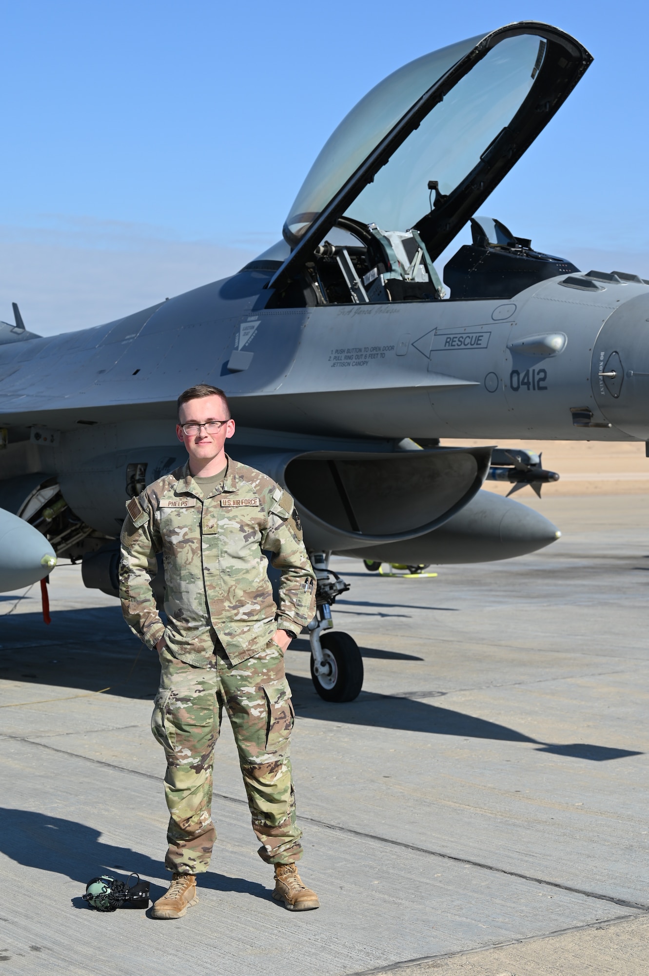 U.S. Air Force Senior Airman Roland Phelps, 378th Air Expeditionary Wing Host Nation Coordination Cell cryptologic language analyst, stands in front of an F-16 Fighting Falcon in a U.S. Central Command area of responsibility, Nov. 26, 2024.