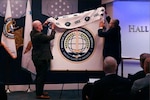 DSCA Director Mike Miller and DSCS Director Saul Bracero unveil the DSCS logo at the opening ceremony of DSCS