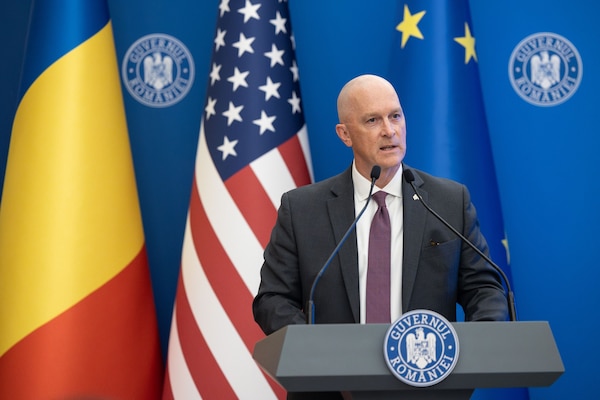 Director of DSCA Mr. Michael Miller stands at a podium with Romanian and American flags behind him as he discussed the $920 million FMF direct loan to our partner and ally, Romania.