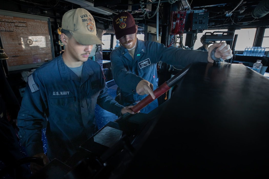 Sailors man the helm aboard USS Cole (DDG 67) in the U.S. Central Command area of responsibility.