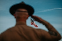 A U.S. Marine Corps drill master with Recruit Regiment salutes the colors during a graduation ceremony for Golf Company, 2nd Recruit Training Battalion, at Marine Corps Recruit Depot San Diego, California, Nov. 26, 2024. Graduation took place at the completion of the 13-week transformation, which included training for drill, marksmanship, basic combat skills, and Marine Corps customs and traditions. (U.S. Marine Corps photo by Cpl. Alexander O. Devereux)