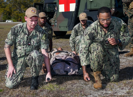 Sailors transport a simulated casualty during a training event at the Healthcare Simulation and Bioskills Center, on November 25, 2024. The joint training tested Sailors on the multiple stages of healthcare providing in an active combat zone.