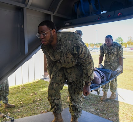 Retail Specialist 3rd class Donal Johnson and Hospital Corpsman 2nd class Dakota Crosby transport a simulated casualty during a training event at the Healthcare Simulation and Bioskills Center, on November 25, 2024. The joint training tested Sailors on the multiple stages of healthcare providing in an active combat zone.