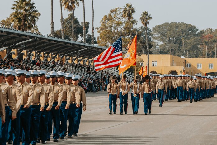 U.S. Marines with the regimental color guard lead Golf Company, 2nd Recruit Training Battalion, as they march across the parade deck during their graduation ceremony at Marine Corps Recruit Depot San Diego, California, Nov. 26, 2024. Graduation took place at the completion of the 13-week transformation, which included training for drill, marksmanship, basic combat skills, and Marine Corps customs and traditions. (U.S. Marine Corps photo by Cpl. Alexander O. Devereux)