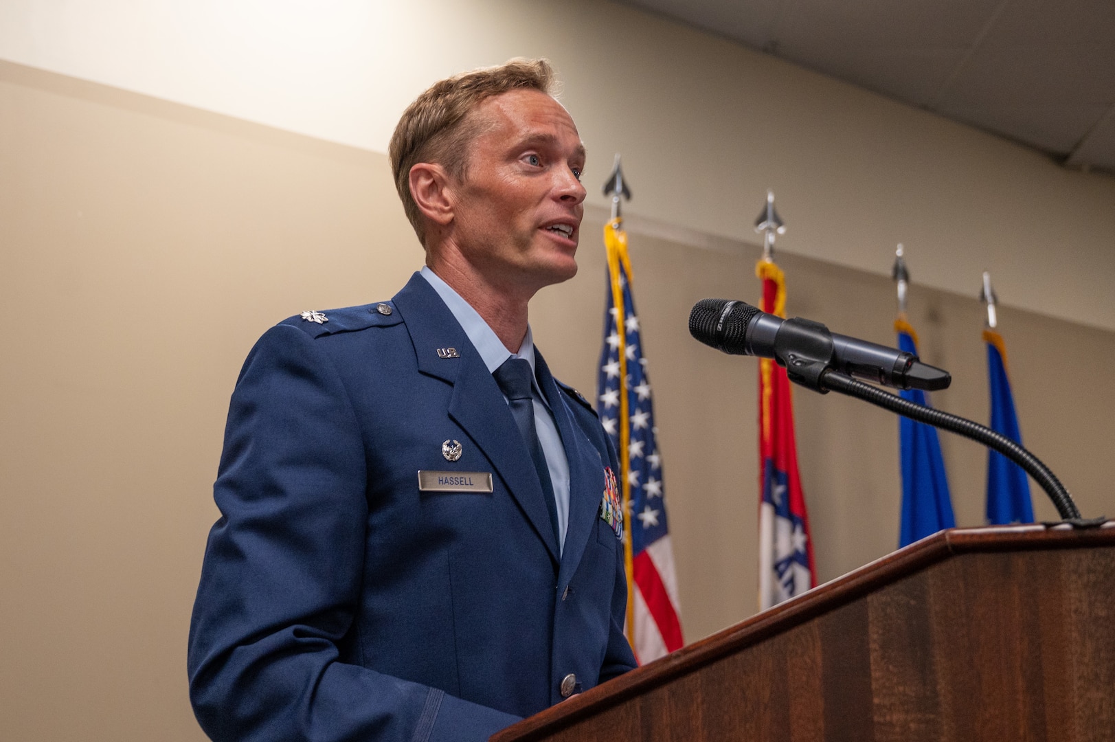 LtC Hassell, 57th Fighter Squadron commander, speaks from behind a podium during a ceremony for the reactivation of the 85th Fighter Group and 57th Fighter Squadron.