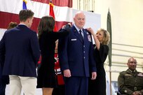 The family of Brig. Gen. Daniel R. McDonough, Assistant Adjutant General - Air, Illinois National Guard, pen on his new rank at the Peoria Air National Guard Base, Peoria, Illinois Nov. 27.