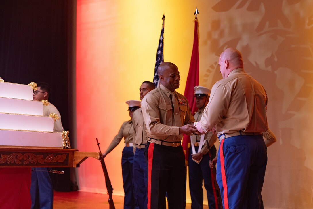 U.S. Marine Corps Brig. Gen. Nick I. Brown, Marine Corps Installations West Commanding General, passes the first piece of cake to Chief Warrant Officer 4 Bruce A. Hall, Security Battalion Corrections Officer and the oldest Marine present at the Camp Pendleton Annual Marine Corps Birthday Pageant and Cake Cutting Ceremony at the Camp Pendleton Base Theater at Marine Corps Base Camp Pendleton, Calif., Nov. 6, 2024. The birthday pageant is an annual tradition that includes a uniform pageant as well as the traditional cake cutting ceremony in honor of the Marine Corps’ birthday. (U.S. Marine Corps photo by Lance Cpl. Jeslianne A. Torres).