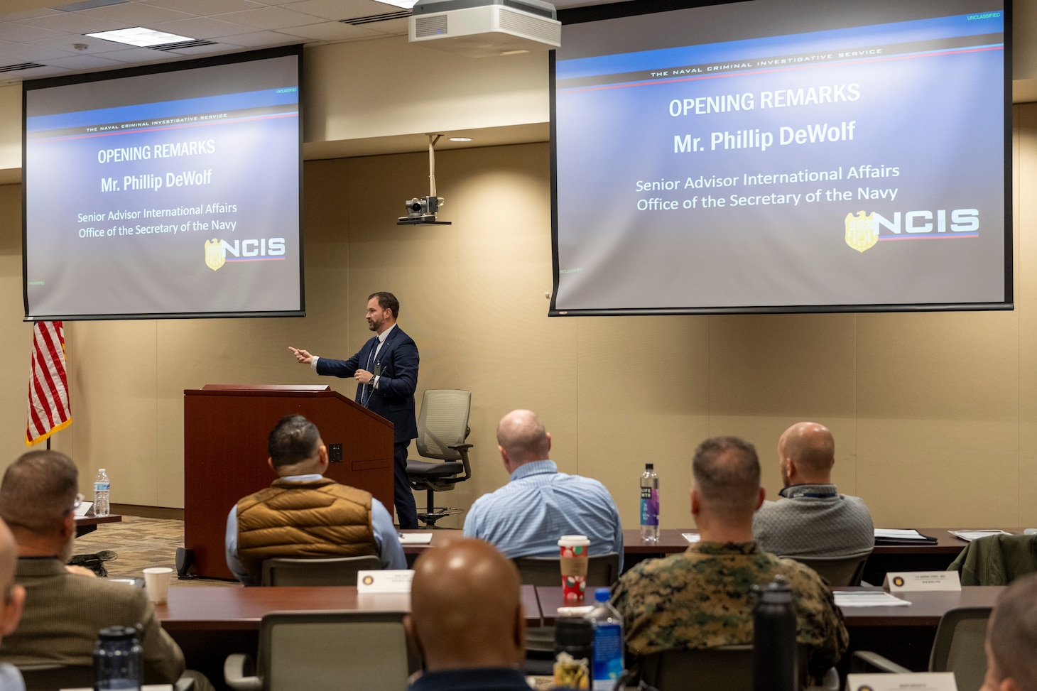 Deputy Under Secretary of the Navy (Policy) Advisor for International Affairs Phillip DeWolf delivers opening remarks at the NCIS Multiple Threat Alert Center Force Protection Intelligence Conference Nov. 19, 2024, at NCIS Headquarters.