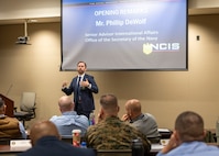 Deputy Under Secretary of the Navy (Policy) Advisor for International Affairs Phillip DeWolf delivers opening remarks at the NCIS Multiple Threat Alert Center Force Protection Intelligence Conference Nov. 19, 2024, at NCIS Headquarters.