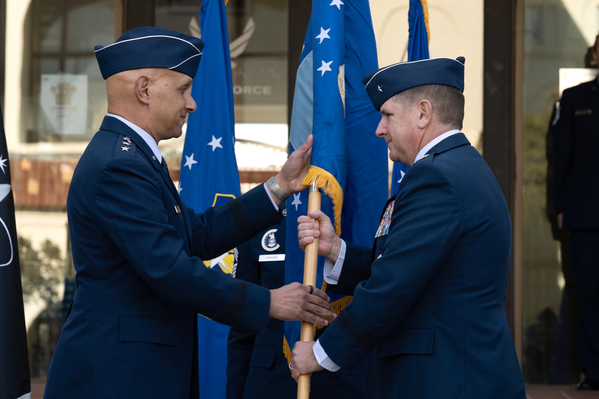 U.S. Air Force Lt. Gen. Brian Robinson (left), commander of Air Education and Training Command, passes the guidon to Brig. Gen. Christopher Amrhein, Air Force Accessions Center incoming commander, during an activation ceremony and assumption of command at Joint Base San Antonio-Randolph, Texas, Dec. 2, 2024.