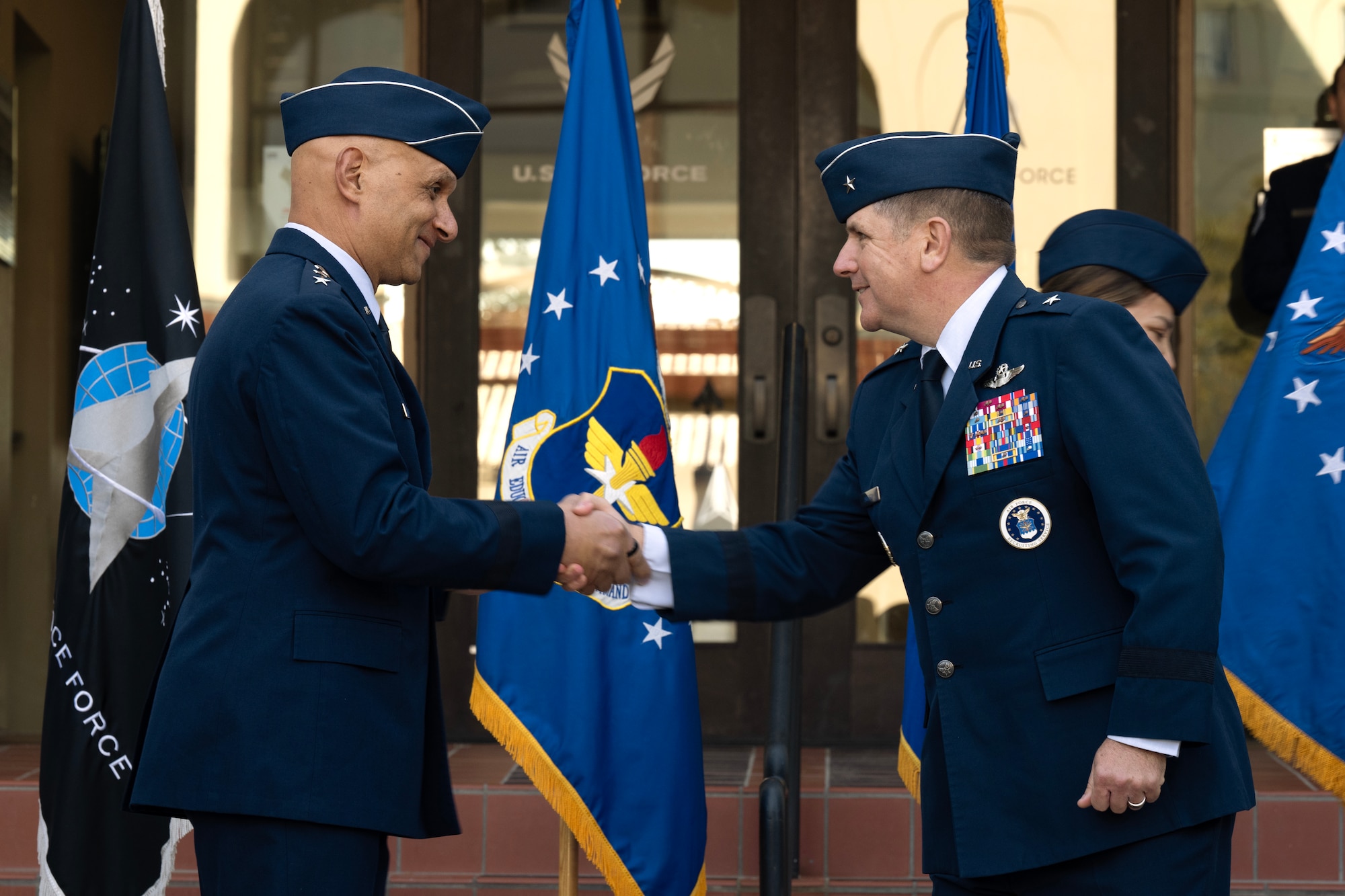 U.S. Air Force Lt. Gen. Brian Robinson (left), commander of Air Education and Training Command, and Brig. Gen. Christopher Amrhein, Air Force Accessions Center commander, shake hands during an activation ceremony and assumption of command at Joint Base San Antonio-Randolph, Texas, Dec. 2, 2024.