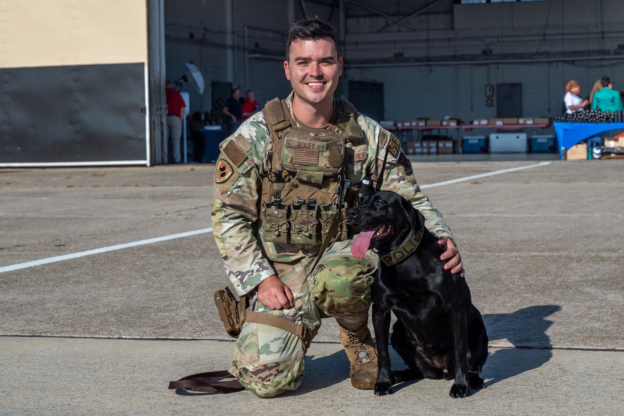 A military working dog handler poses with his dog.