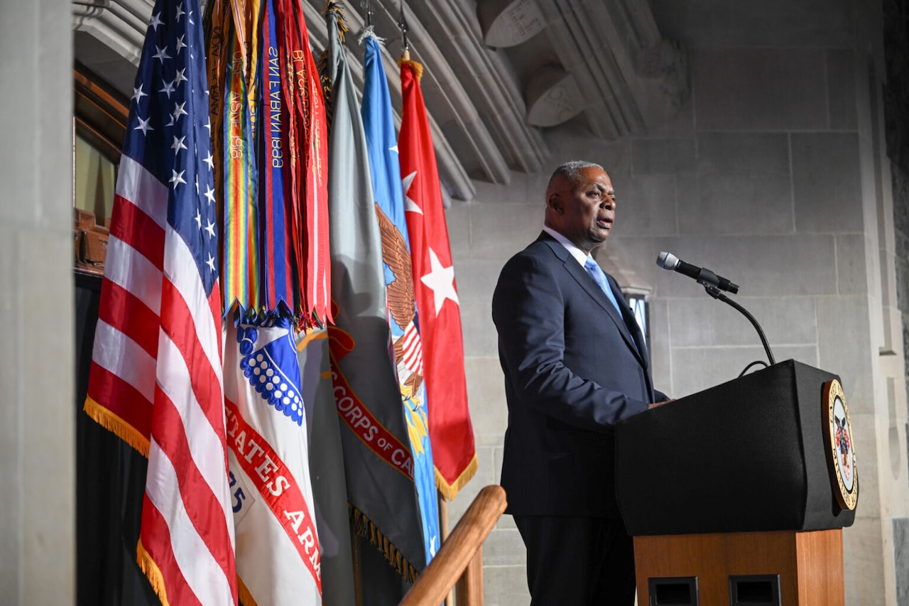A man in business attire stands at a lectern.