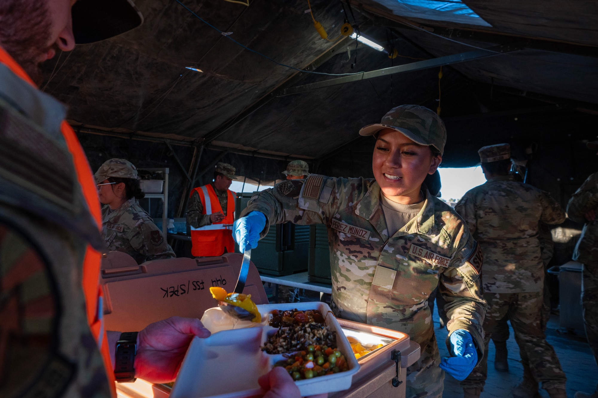 A 944th Fighter Wing Reserve Citizen Airman serves a meal to a fellow Airman during Exercise Desert Hammer 25-1 at Gila Bend Air Force Auxiliary Field near Gila Bend, Ariz., Nov. 14, 2024. Through joint and multinational collaboration, Desert Hammer tests the ability of over 700 participants and 131 aircraft to operate, defend, and sustain airbases under austere conditions. (U.S. Air Force photo by Senior Airman Alexis Orozco)