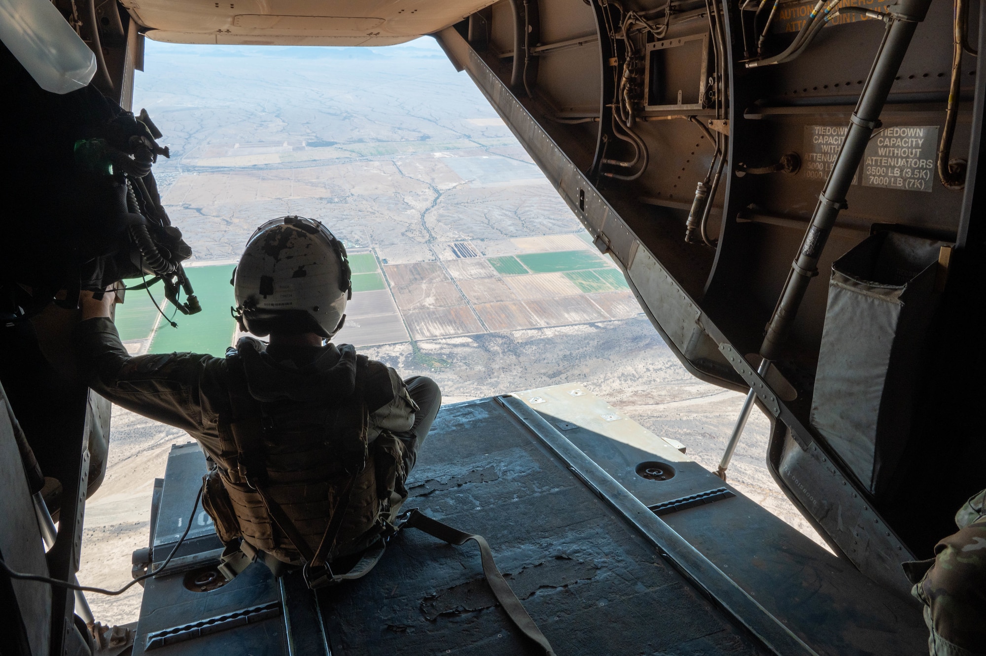A U.S. Marine Corps Medium Tiltrotor Squadron 163 MV-22 Osprey crew member observes the view of southern Arizona below from the aircraft’s ramp during Exercise Desert Hammer 25-1 near Gila Bend, Ariz., Nov. 14, 2024. Set against the unmatched backdrop of the Barry M. Goldwater Range, Desert Hammer leverages Arizona’s strategic geography to provide realistic combat training for U.S. and allied forces. (U.S. Air Force photo by Senior Airman Alexis Orozco)
