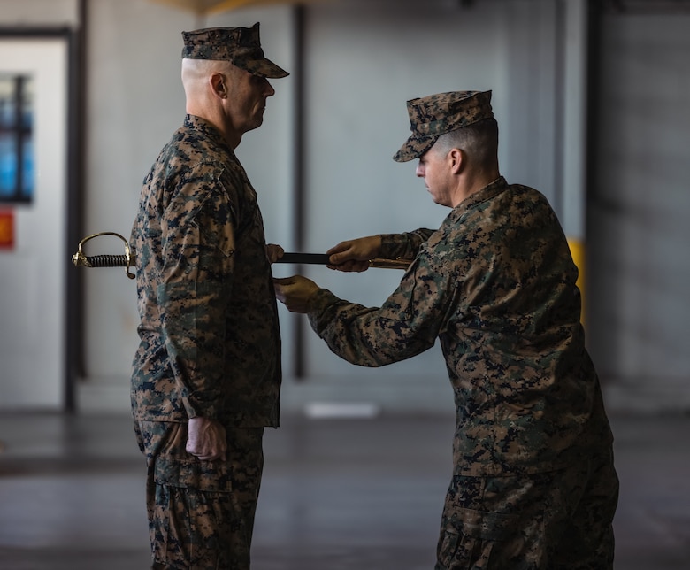 U.S. Marine Corps Col. Scott Warman, left, commanding officer of Marine Corps Air Facility Quantico, receives the Non-Commissioned Officer sword from 1stSgt. Brandon Smart, outgoing senior enlisted leader of MCAF, during a relief and appointment ceremony at MCAF on Marine Corps Base Quantico, Virginia, Dec. 3, 2024. Smart relinquished command to 1stSgt. Christopher Rushton after serving as the command senior enlisted leader for over a year. (U.S. Marine Corps photo by Lance Cpl. Ethan Miller)