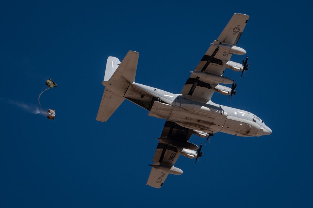 Cargo descends under a parachute from a U.S. Marine Corps KC-130J Hercules during Exercise Desert Hammer 25-1 at Auxiliary Airfield 6 near Gila Bend, Ariz., Nov. 14, 2024. The exercise integrates Agile Combat Support and Large Force Exercise capabilities in a contested environment. (U.S. Air Force photo by Tech. Sgt. Tyler J. Bolken)