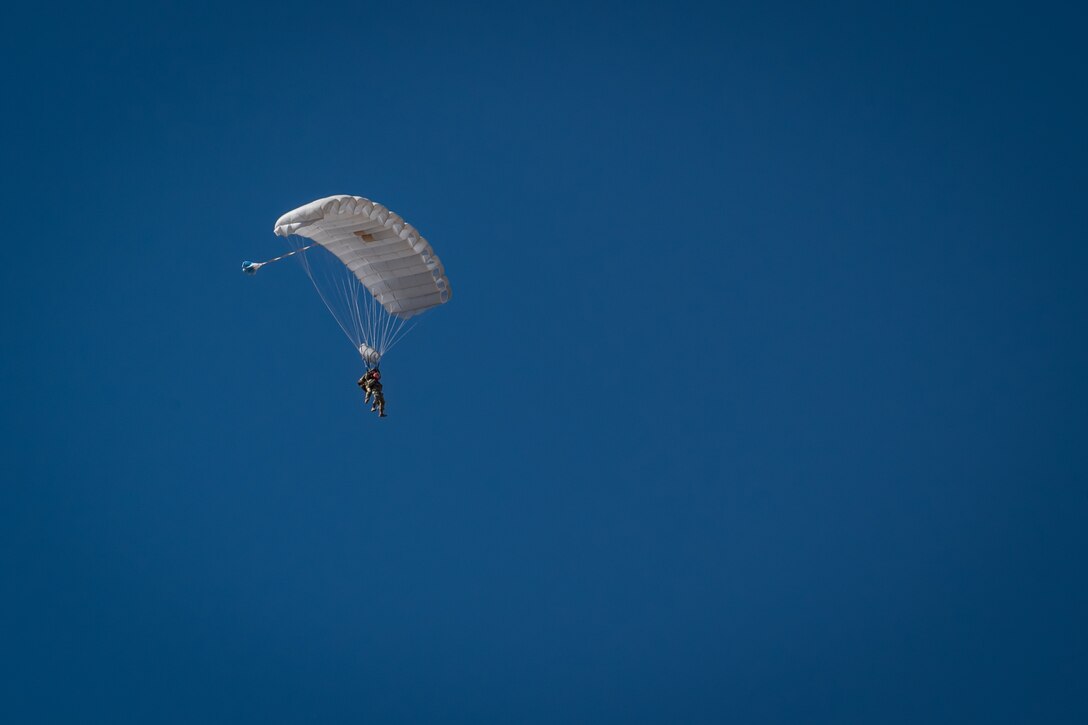 A tandem of U.S. Air Force Airmen glide toward the landing zone during a personnel airdrop as part of Exercise Desert Hammer 25-1 at Auxiliary Airfield 6 near Gila Bend, Ariz., Nov. 14, 2024. This large-scale exercise showcases the adaptability of Mission Ready Airmen, advancing the skills needed to thrive in the rapidly evolving challenges of global competition. (U.S. Air Force photo by Tech. Sgt. Tyler J. Bolken)