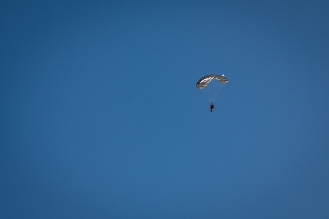 A U.S. Air Force Airman descends under canopy during a personnel airdrop at Exercise Desert Hammer 25-1, held at Auxiliary Airfield 6 near Gila Bend, Ariz., Nov. 14, 2024. Through joint and multinational collaboration, Desert Hammer tests the ability of over 700 participants and 131 aircraft to operate, defend, and sustain airbases under austere conditions. (U.S. Air Force photo by Tech. Sgt. Tyler J. Bolken)
