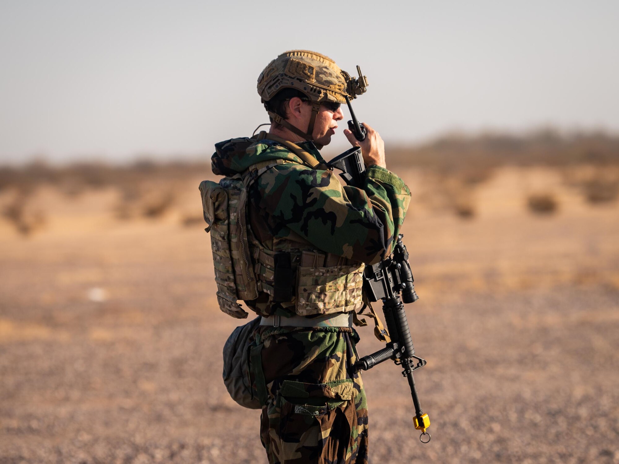 A 944th Fighter Wing U.S. Air Force Reserve Citizen Airman dawns Mission Oriented Protective Posture (MOPP) gear and communicates via radio during Exercise Desert Hammer 25-1 at Auxiliary Field 6 near Gila Bend, Ariz., Nov. 15, 2024. Set against the unmatched backdrop of the Barry M. Goldwater Range, Desert Hammer leverages Arizona’s strategic geography to provide realistic combat training for U.S. and allied forces. (U.S. Air Force photo by Senior Airman Jacob Dastas)