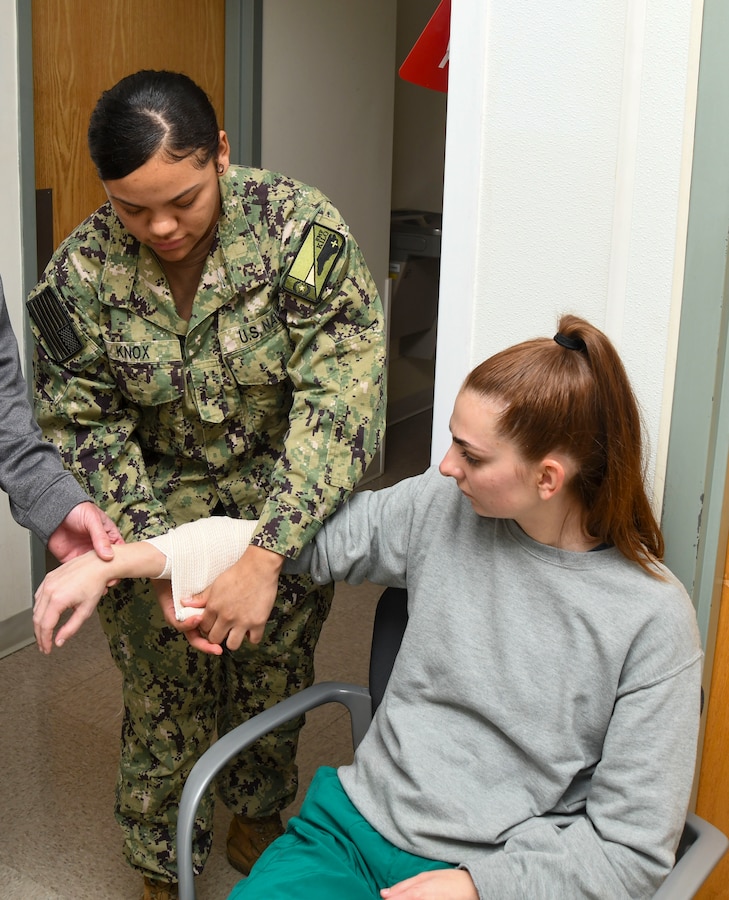 Hospitalman Amarian Knox applies a bandage to a simulated wound during a training event at the Healthcare Simulation and Bioskills Center, on November 25, 2024. The joint training tested Sailors on the multiple stages of healthcare providing in an active combat zone.