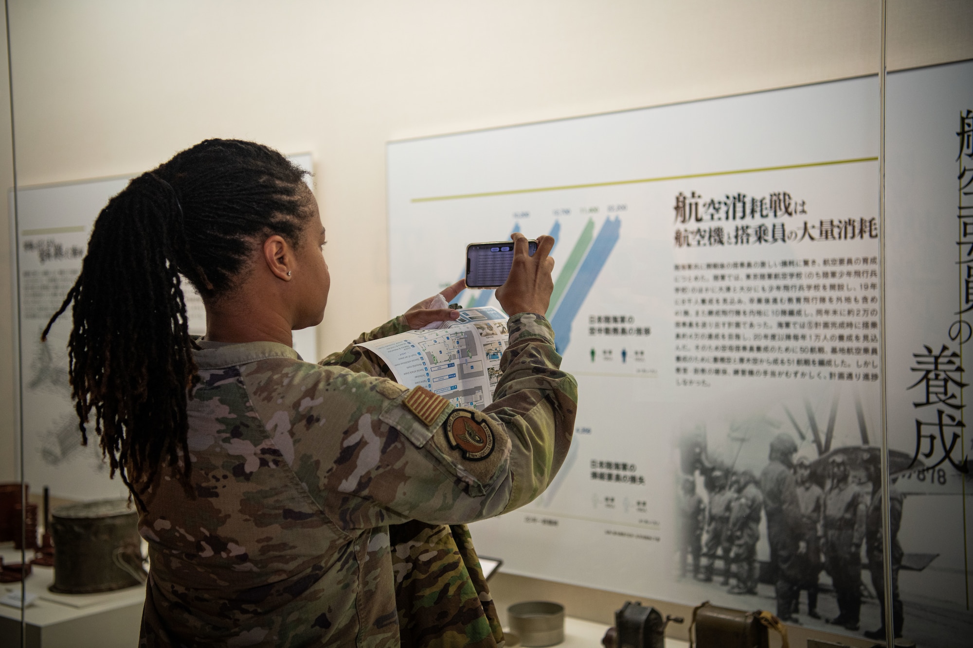 Airman translates a Japanese poster at the Iruma Air Museum.