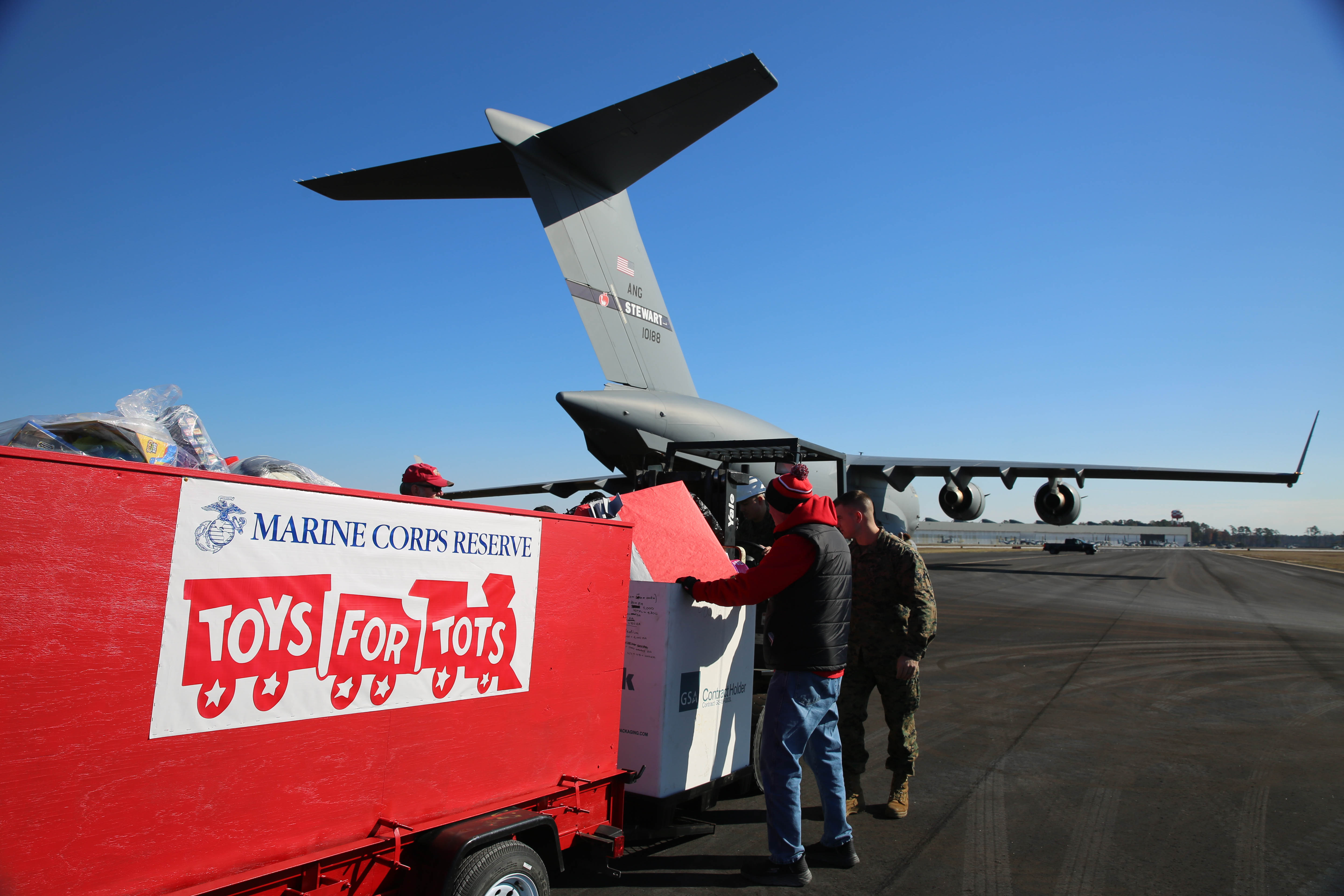 Service members and veterans load thousands of toys onto a trailer at Marine Corps Air Station New River, Jacksonville, N.C., Dec. 3, 2024.
