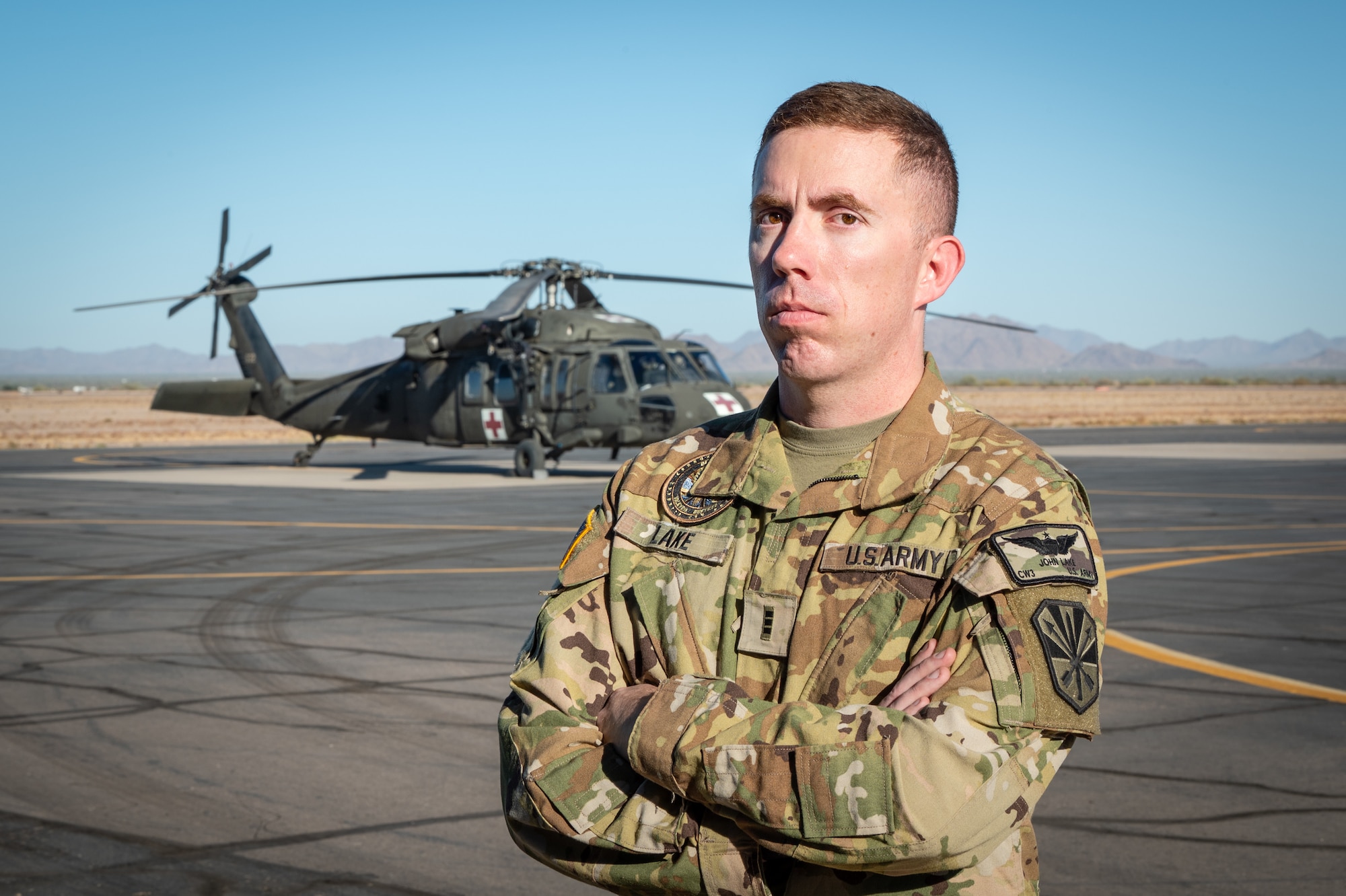 Arizona Army National Guard Chief Warrant Officer 3 Jonathan Lake, a UH-60 MedEvac Instructor Pilot, poses in front of a UH-60 Black Hawk during Exercise Desert Hammer 25-1 at Gila Bend Air Force Auxiliary Field near Gila Bend, Ariz., Nov. 14, 2024. This large-scale exercise showcases the adaptability of Mission Ready Airmen, advancing the skills needed to thrive in the rapidly evolving challenges of global competition. (U.S. Air Force photo by Tech. Sgt. Tyler J. Bolken)