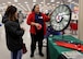 A woman spins a prize wheel while another woman watches at the Post Exchange