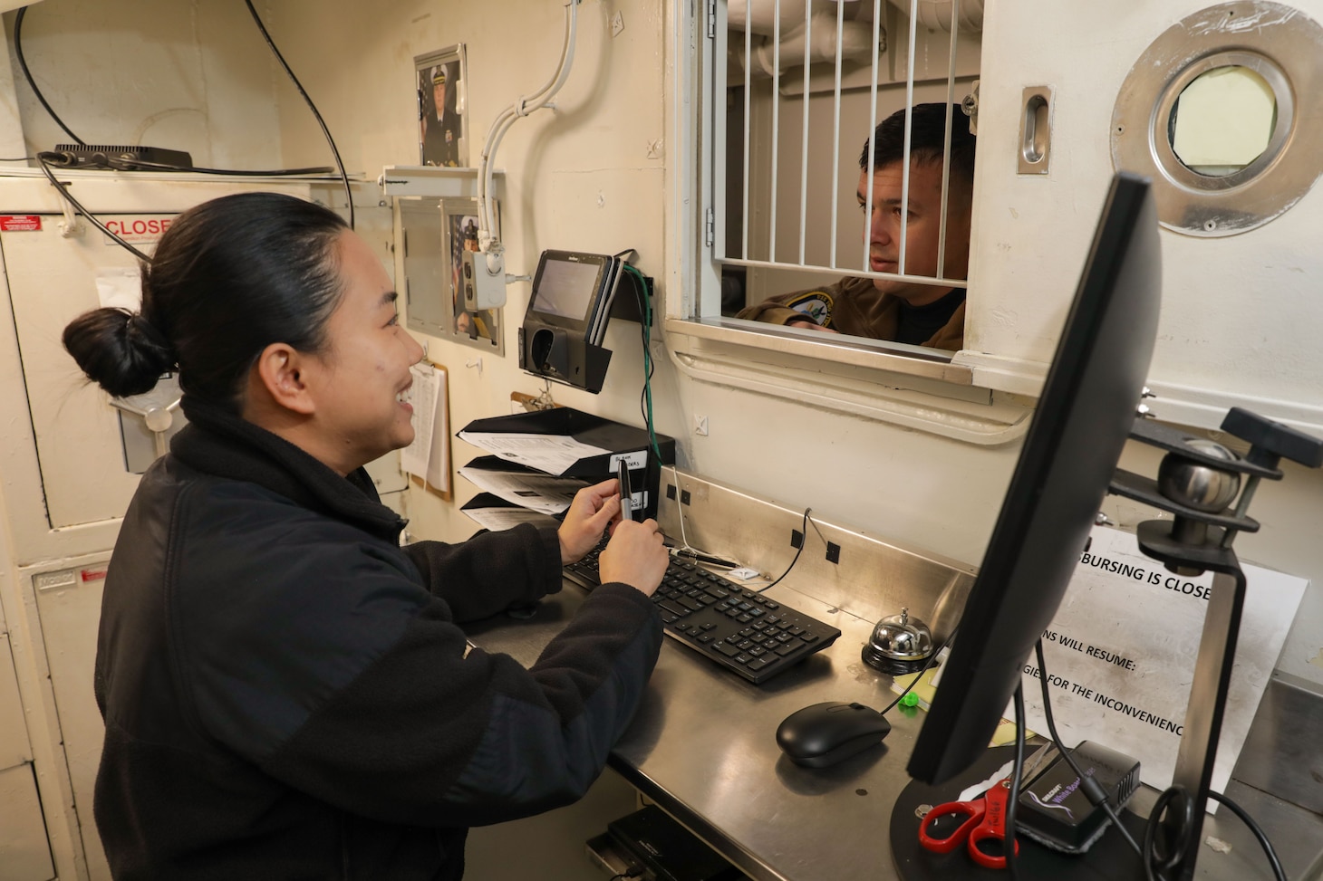 Ensign Thuong Nguyen, the disbursing officer assigned to the Wasp-Class amphibious assault ship USS Iwo Jima (LHD 7), talks to Lt. Brock Smith in the disbursing office onboard, Dec. 3, 2024. Nguyen is from Dak Lak, Vietnam and came to the U.S. in 2013 where she would eventually join the Navy as a Supply Corps Officer in 2023. Amphibious assault ships like Iwo Jima have crews with rich diversity and heritage, which enhances the Navy’s unity and culture.