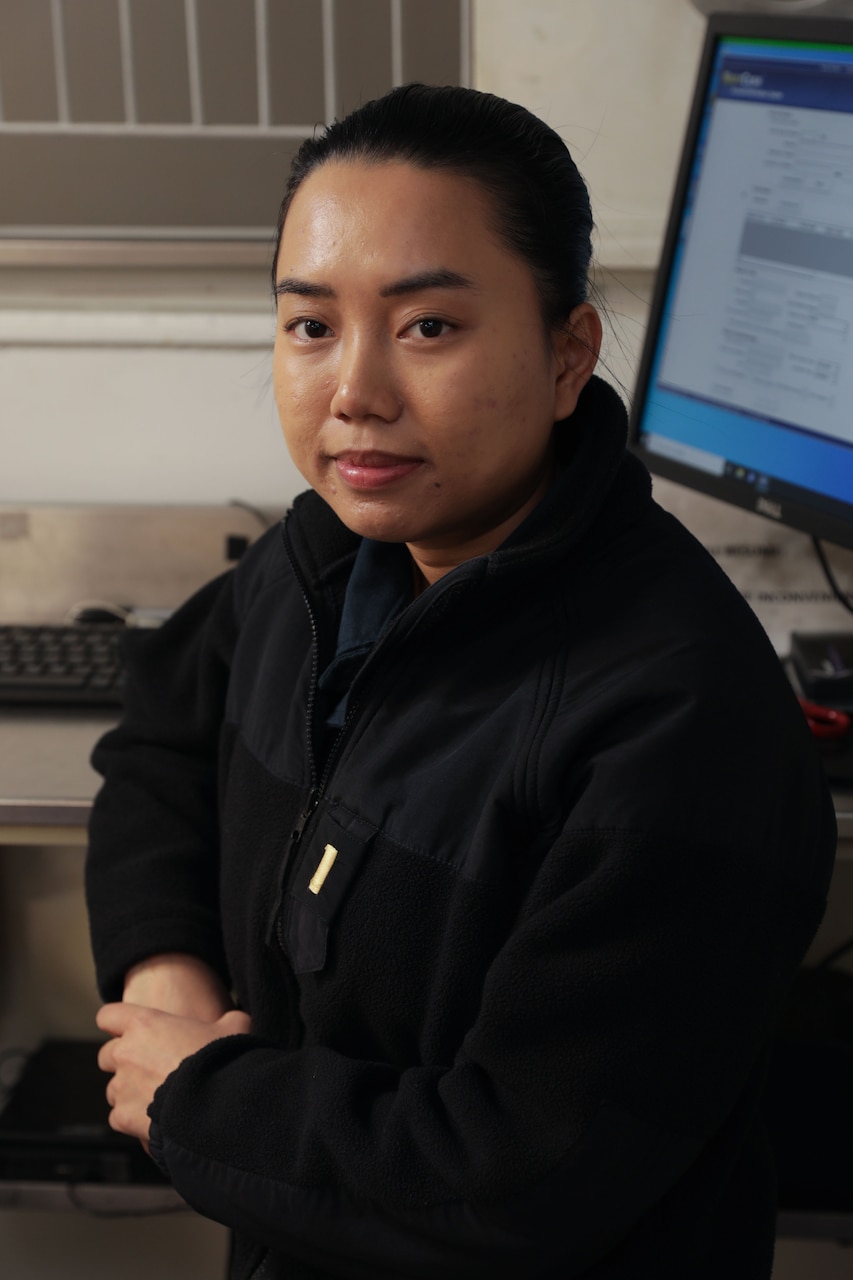 Ensign Thuong Nguyen, the disbursing officer assigned to the Wasp-Class amphibious assault ship USS Iwo Jima (LHD 7), poses for a photo in the disbursing office onboard, Dec. 3, 2024. Nguyen is from Dak Lak, Vietnam and came to the U.S. in 2013 where she would eventually join the Navy as a Supply Corps Officer in 2023. Amphibious assault ships like Iwo Jima have crews with rich diversity and heritage, which enhances the Navy’s unity and culture.