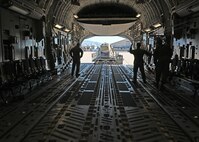 Airmen load cargo onto a C-17