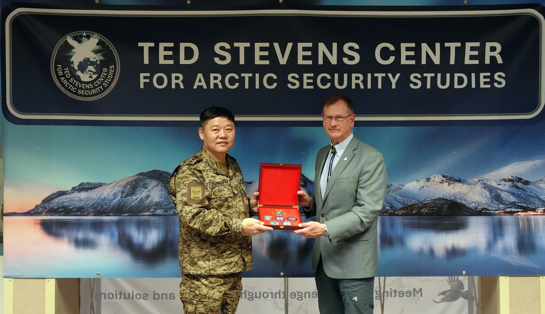 Colonel T. Galbadrakh, Deputy Chief of the General Staff of the Mongolian Armed Forces, presents Randy “Church” Kee, Director of the Ted Stevens Center for Arctic Security Studies, coins during a visit