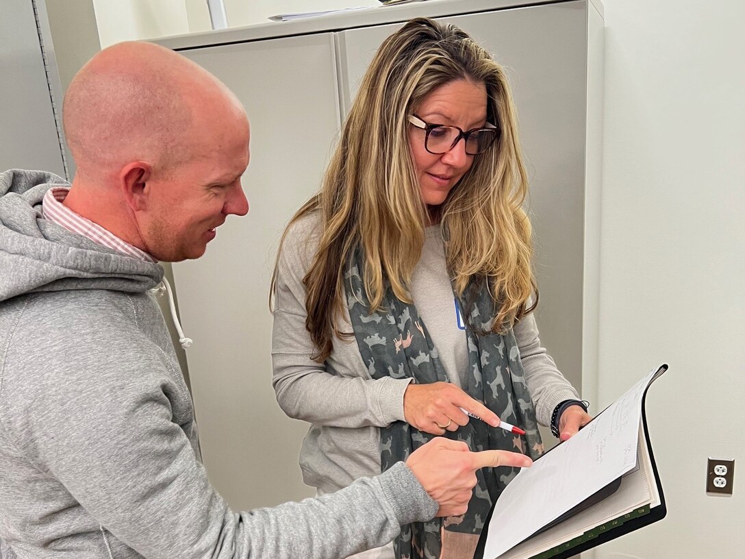 Physical Therapist Brett Clingerman and his colleague Occupational Therapist Joy Davis reviewed notes from the 2024 OT/PT and Post Traumatic Growth Summit at Fort Belvoir, Virginia, on December 4, 2024.