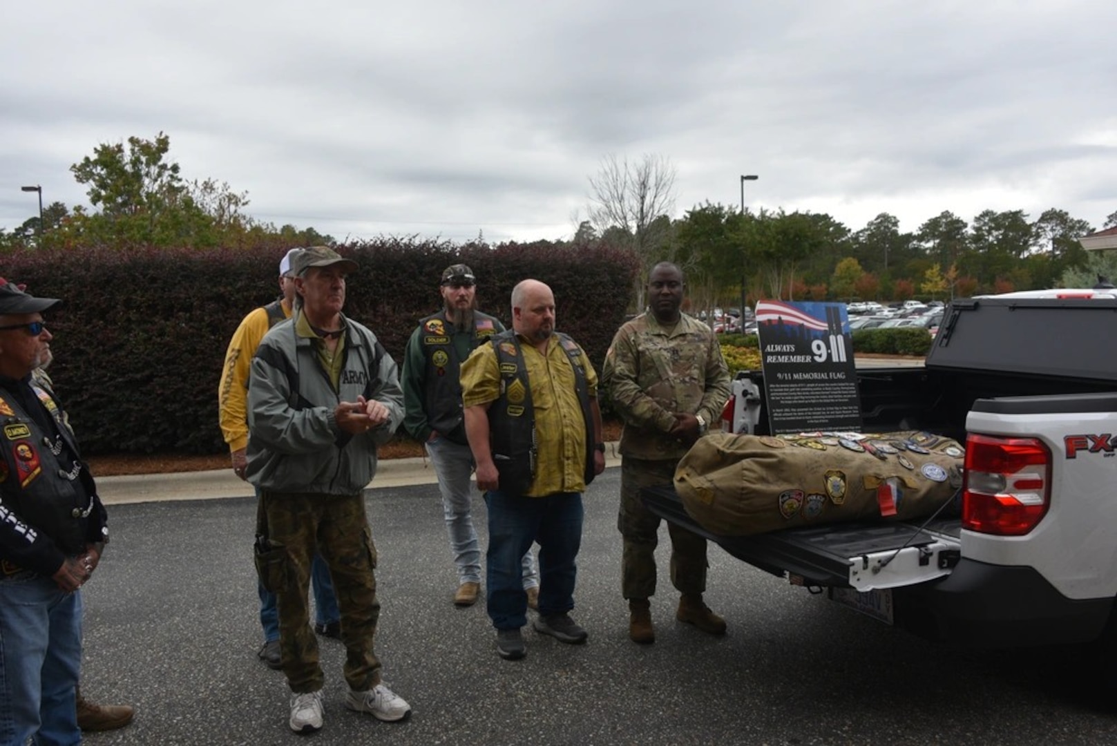 Thomas McBrien, (left front) curator of the 9/11 Memorial Flag addresses staff and visitors before the blessing of the flag in front of Womack Army Medical Center, Fort Liberty, North Carolina.