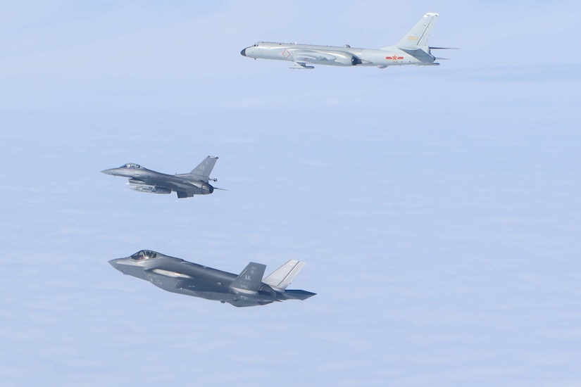 Aircraft fly in a clear Alaskan sky.