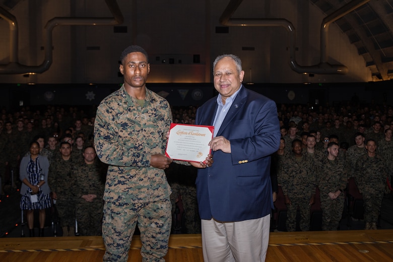 Secretary of the Navy Carlos Del Toro poses for a photo with U.S. Marine Corps Cpl. Regis E. Bayou, an aircraft maintenance support equipment technician with Marine Aviation Logistics Squadron 16, Marine Aircraft Group 16, 3rd Marine Aircraft Wing after Bayou’s reenlistment ceremony at Marine Corps Air Station Miramar, California, Dec. 4, 2024. Secretary Del Toro toured the installation to engage with servicemembers and assess ongoing efforts to improve quality of life, operational readiness, and infrastructure at MCAS Miramar. (U.S. Marine Corps photo by Sgt. Santicia Ambriez-Stippey)
