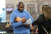Capt. Darien Hoskin holds his new baby after arriving at Abraham Lincoln Capital Airport in Springfield, Illinois Nov. 21.