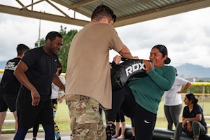 (Left) U.S. Army Sgt. Eric Moshay and (right) Spc. Ty McCarter, Army Forces Command, Joint Task Force-Bravo, teach a Honduran Air Force service member combatives during the EmpowerHER combatives class at Soto Cano Air Base, Honduras, Dec. 3, 2024.