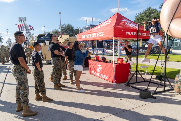 U.S. Marines with Recruiting Station Houston, 8th Marine Corps District, watch an attendee conduct pull-ups during the Houston Texans vs. Tennessee Titans football game at NRG Stadium in Houston, Texas, Nov. 24, 2024. The Marines challenged fans and attendees with a pull-up challenge to win prizes to support the National Football League's Salute To Service game along with the other military branches. (U.S. Marine Corps photo by Sgt. Ryan H. Pulliam)