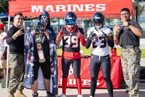 U.S. Marine Corps Staff Sgt. William Cary, far left, a recruiter with Recruiting Sub Station Pearland, Recruiting Station Houston, and Sgt. Jesusaleja Arredondo, far right, a recruiter with RSS Baybrook, RS Houston, pose for a photo with football fans during the Houston Texans vs. Tennessee Titans football game at NRG Stadium in Houston, Texas, Nov. 24, 2024. Marines with RS Houston challenged fans with a pull-up challenge to win prizes to support the National Football League's Salute To Service game along with the other military branches. (U.S. Marine Corps photo by Sgt. Ryan H. Pulliam)
