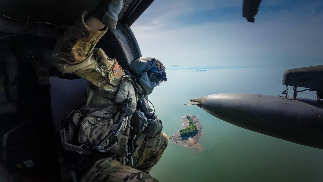 A U.S. Army aircrew Soldier aboard a HH-60 Blackhawk helicopter with the 2nd Combat Aviation Brigade, 2nd Infantry Division, looks out the door over South Korea while participating in Dragon Lift 2024, June 26, 2024.