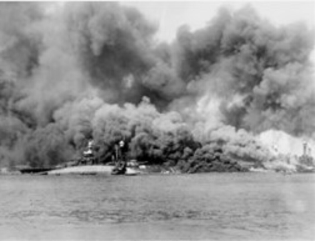The USS Oklahoma, struck by enemy bombs and torpedoes before capsizing. Badly damaged by the attack on Pearl Harbor, the ship would be salvaged in 1943 before sinking in a storm on the way to California in 1947.