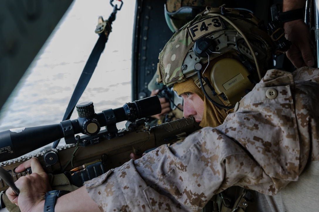 A U.S. Marine with Force Reconnaissance Platoon, Maritime Raid Force, 31st Marine Expeditionary Unit, sights in during an aerial live-fire exercise out of aSH-60 Sea Hawk assigned to Marine Light Attack Helicopter Squadron (HMLA) 267 on W-174, Okinawa, Japan, Dec. 4 2024. The exercise focuses on proficiency in engaging targets from an aircraft. The 31st MEU, the Marine Corps’ only continuously forward-deployed MEU, provides a flexible and lethal force ready to perform a wide range of military operations as the premiere crisis response force in the Indo-Pacific region. (U.S. Marine Corps photo by Pfc. Skilah Sanchez)