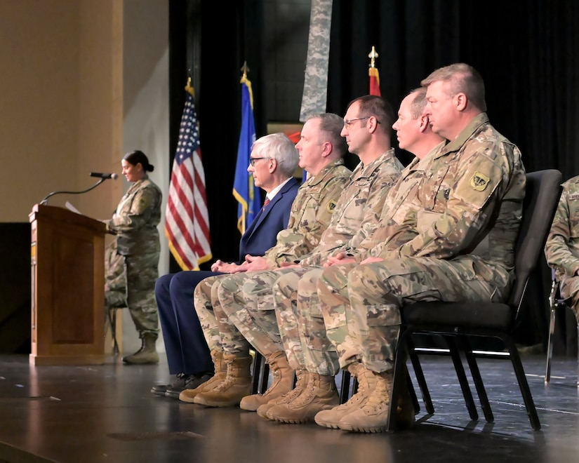 Wisconsin National Guard senior leaders join Wisconsin Gov. Tony Evers at a deployment sendoff ceremony for the 732nd Combat Support Sustainment Battalion’s Headquarters and Headquarters Company Nov. 30, 2024, at Tomah High School in Tomah, Wisconsin. Following pre-mobilization training, the Guardsmen will deploy to the U.S. Central Command area of operations to synchronize and control logistics operations supporting Operation Inherent Resolve.