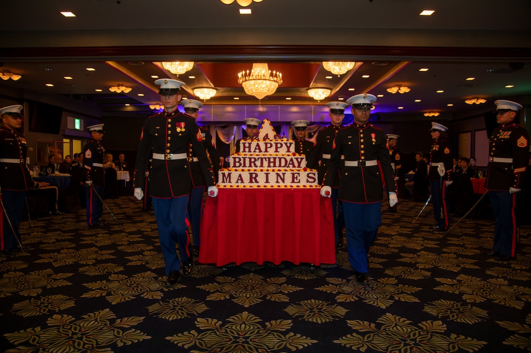 U.S. Marines with Marine Corps Air Station Iwakuni carry 249th Marine Corps Birthday Cake away after the end of the cake cutting ceremony at the 2024 Dignitary Ball at MCAS Iwakuni, Japan, November 13, 2024. MCAS Iwakuni leaders hosted the 2024 Dignitary Ball to continue building and maintaining cooperation, trust, and a positive relationship between themselves and the local community leaders. (U.S. Marine Corps photo by Sgt. Randall Whiteman)